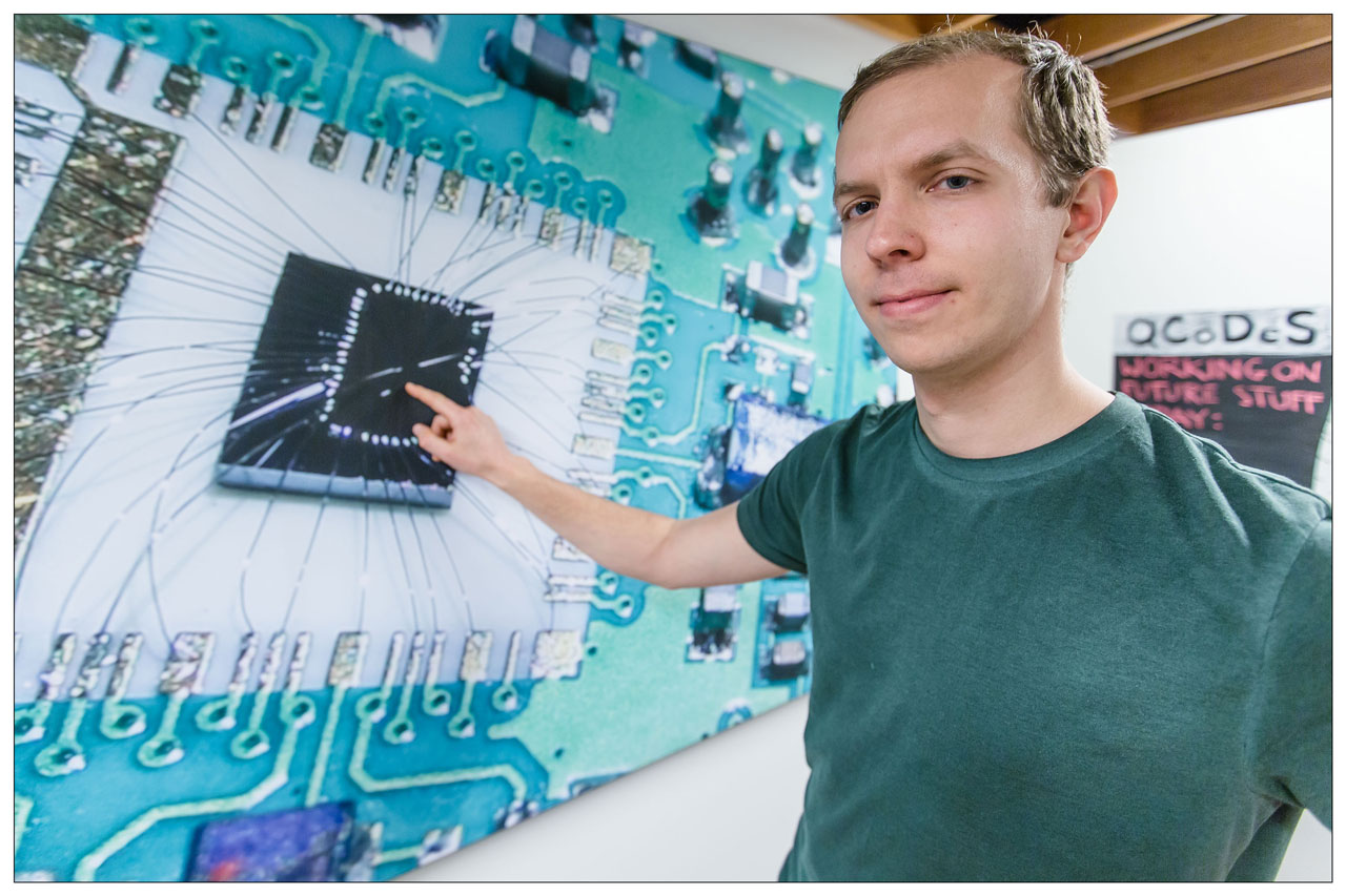 Filip Malinowski – pointing at a chip similar to the one which the NBI-scientists used in their experiments in order to put qubits into reverse.