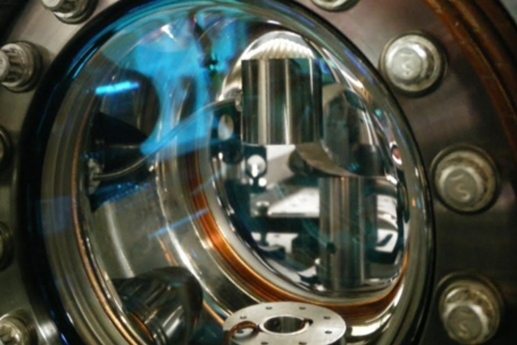 The shiny tungsten cylinder can be seen at top through a window into the vacuum chamber of the atom interferometer The cesium atoms are launched upwards through the circular opening below the cylinder