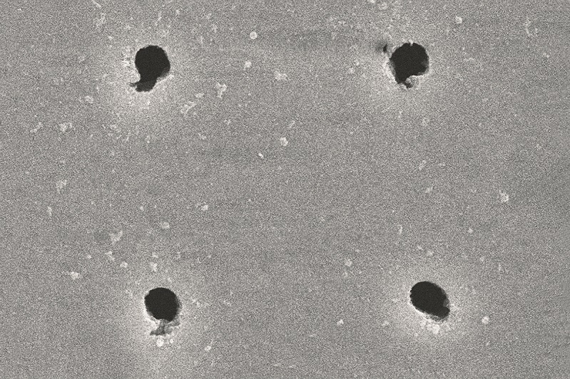 Holes with exit diameter of one micrometer in 10 micrometer thick stainless steel foil with 10 micrometer spacing