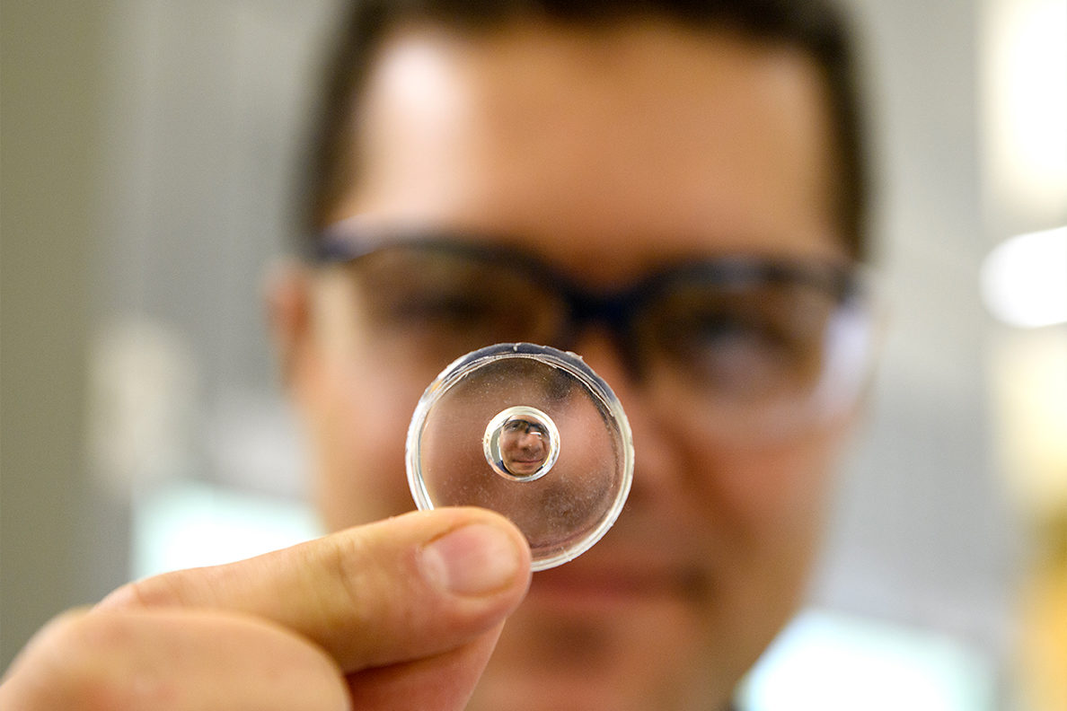 Graduate student Mojtaba Falahati holds a homemade lens.