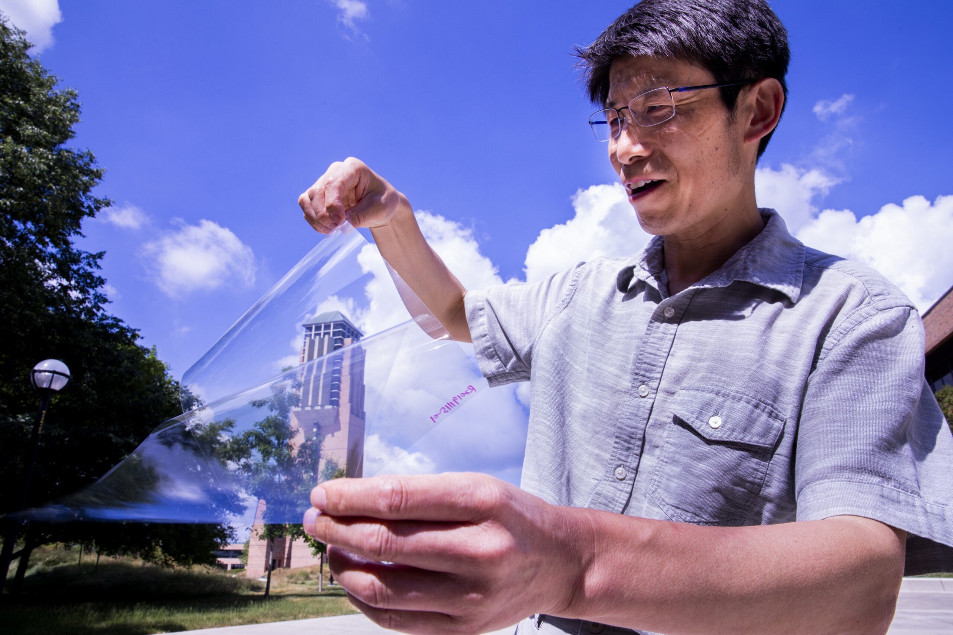 Jay Guo holds a sheet of flexible transparent conductor on the University of Michigan’s College of Engineering North Campus