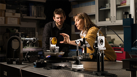 Jannick Roland works with a graduate student on a freeform lens experiment