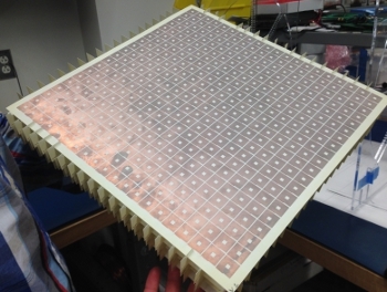 A closer look at the metamaterial “superlens” that beams electromagnetic fields to increase the range of wireless power transfers. The squares are actually long coils of copper wire reminiscent of the surface of a microchip. Credit courtesy of Duke University