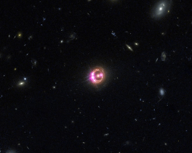 Multiple images of a distant quasar are visible in this combined view from NASA’s Chandra X-ray Observatory and the Hubble Space Telescope