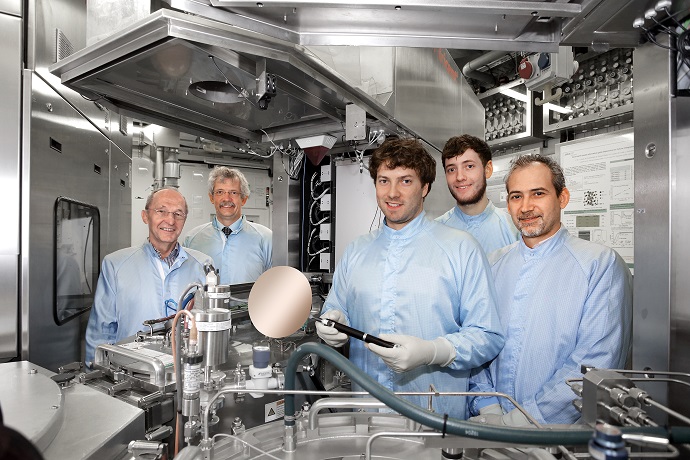 Scientists from the Peter Grünberg Institute standing next to a CVD system