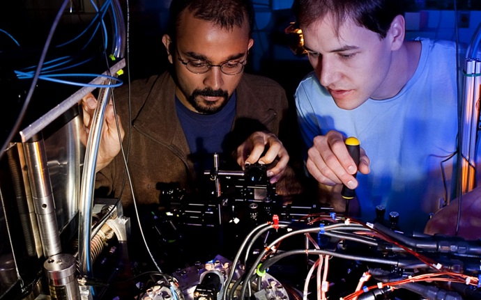 Lead author Varun Vaidya and former graduate student Creston Herold work on the apparatus