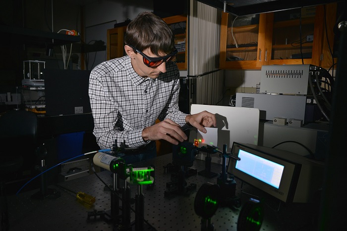 Kent State University chemical physics graduate student Andrii Varanytsia demonstrates laser emission with a liquid crystal elastomer in Professor Peter Palffy-Muhoray’s lab