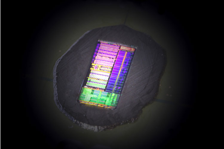 The illumination and camera create a rainbow-colored pattern across the electronic-photonic processor chip