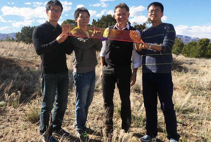 Los Alamos Center for Advanced Solar Photophysics researchers hold a large prototype solar window