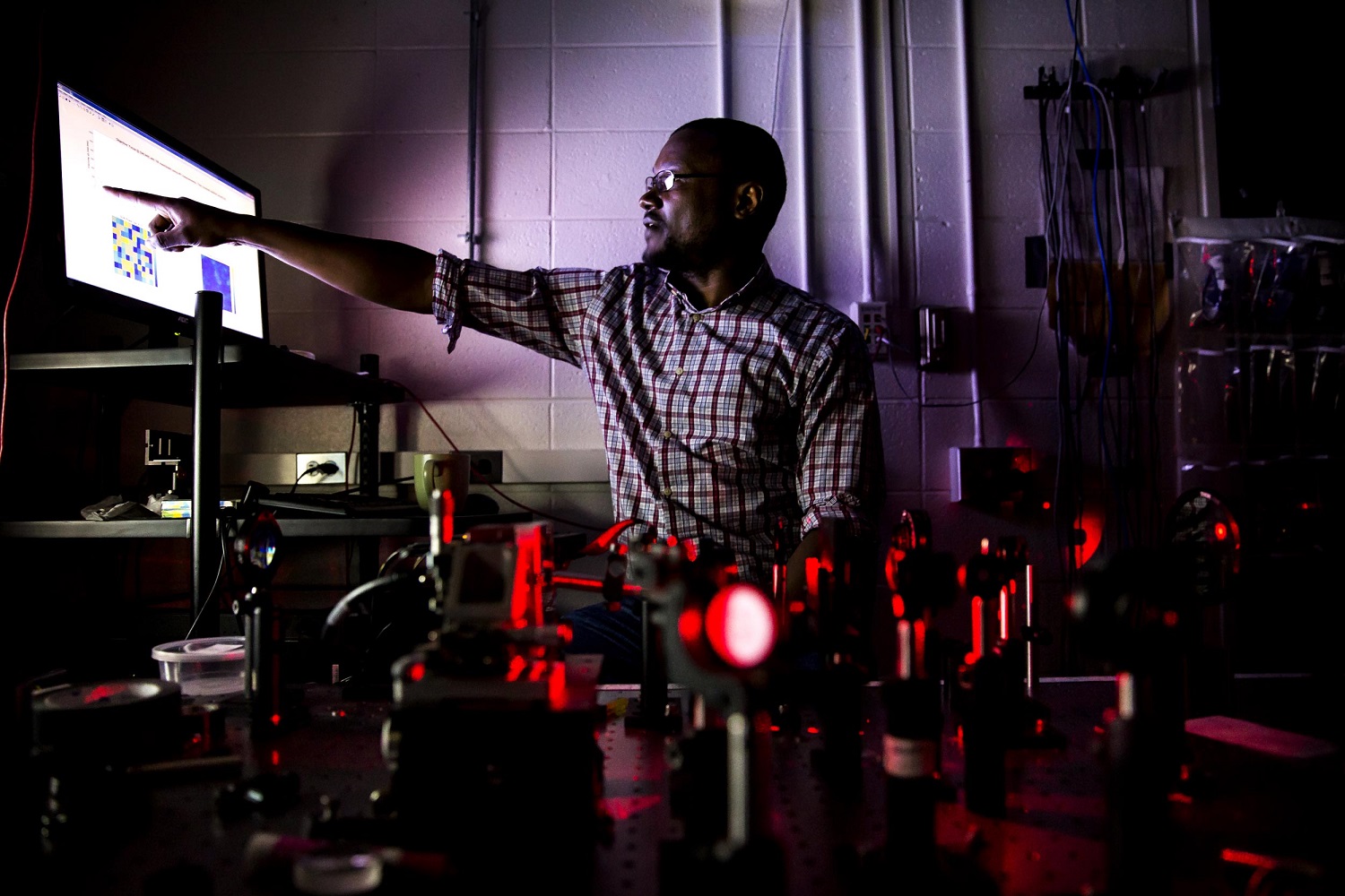 Moussa N'Gom points to a display showing how the yogurt scatters light