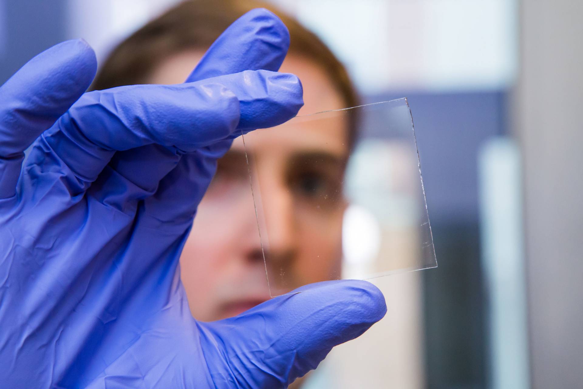 Graduate student Nicholas Davy holds a sample of the special window glass