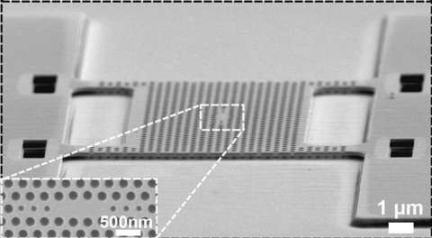 An electron microscope image of the perforated membrane with the crystal cavity in the middle. Detail: the crystal cavity which captures light.