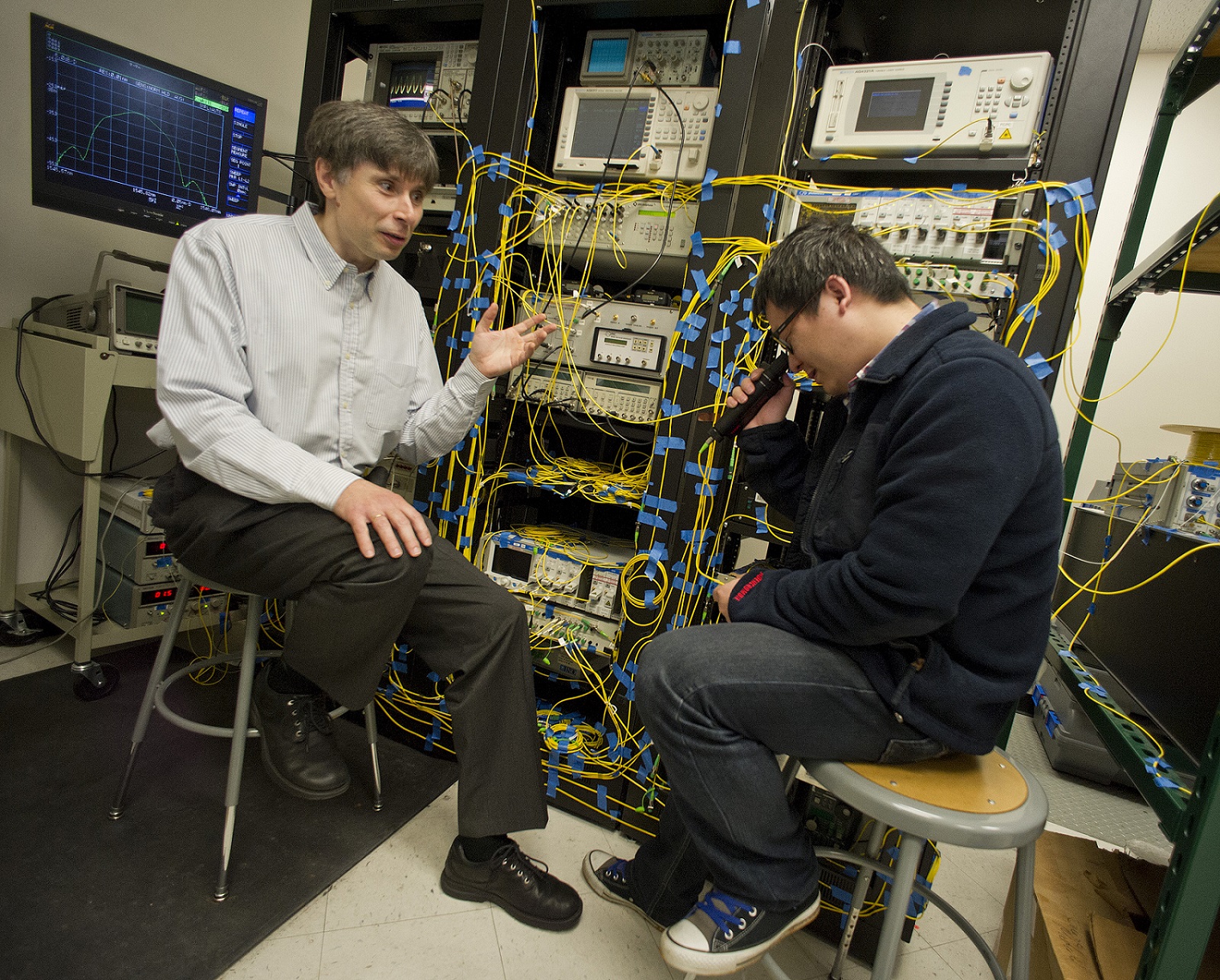 Michael Vasilyev, left, a UTA electrical engineering professor, speaks with one of his graduate students.