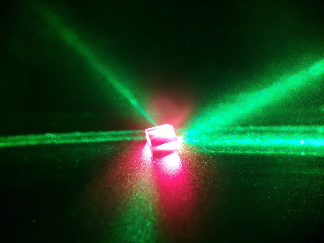 A diamond containing nitrogen-vacancy (NV) defects centres is illuminated by a 532-nm green laser