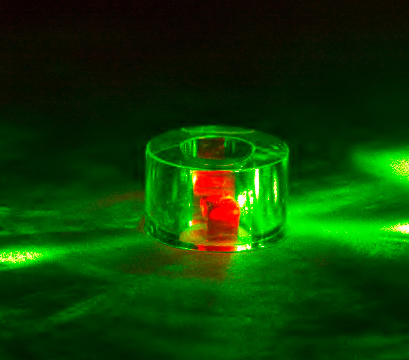 The diamond is held inside a sapphire ring and illuminated by 532-nm green laser