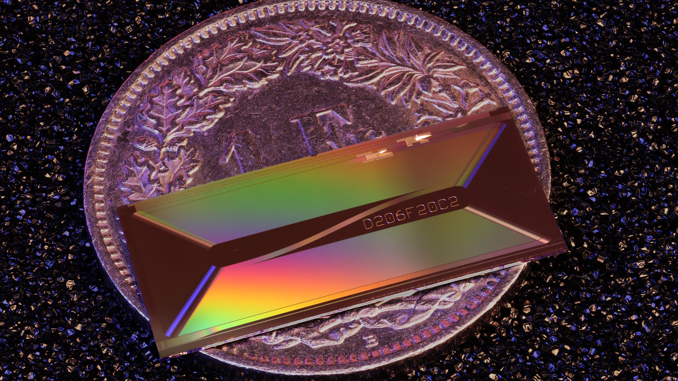 Placed on a 1 CHF coin for scale, EPFL's photonic chip shows how a laser architecture once confined to table-top systems can be shrunk to the millimeter scale.