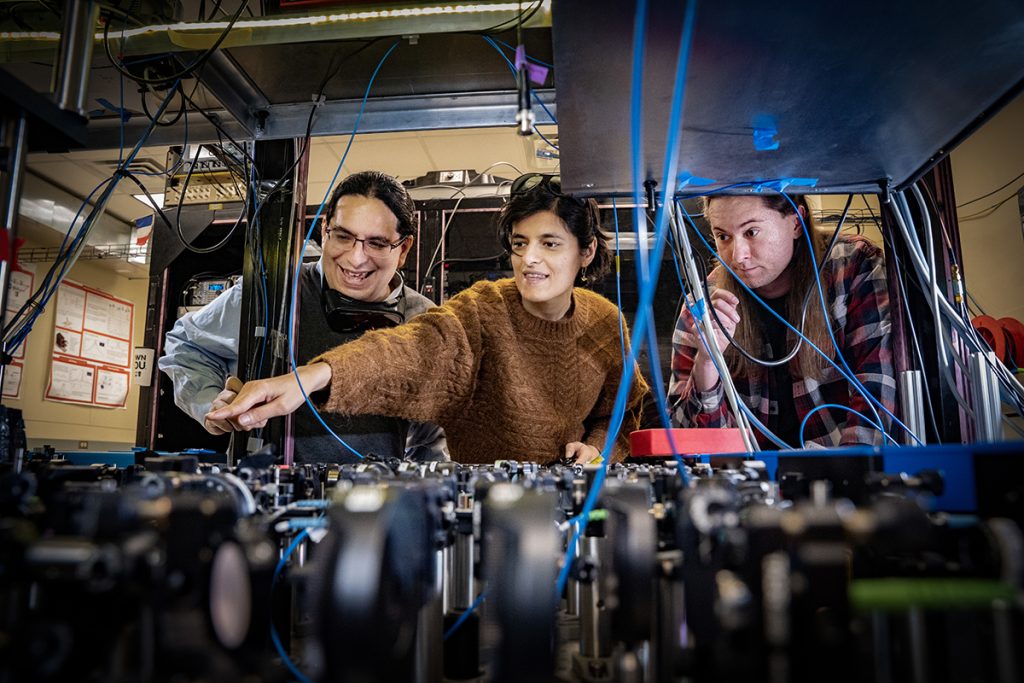 In his Stony Brook Quantum Information Laboratory, lead researcher Eden Figueroa, left, with his collaborators in research investigating quantum internet capacities, Sonali Gera, and Chase Wallace. They hope to be on the path to making a quantum internet a reality.